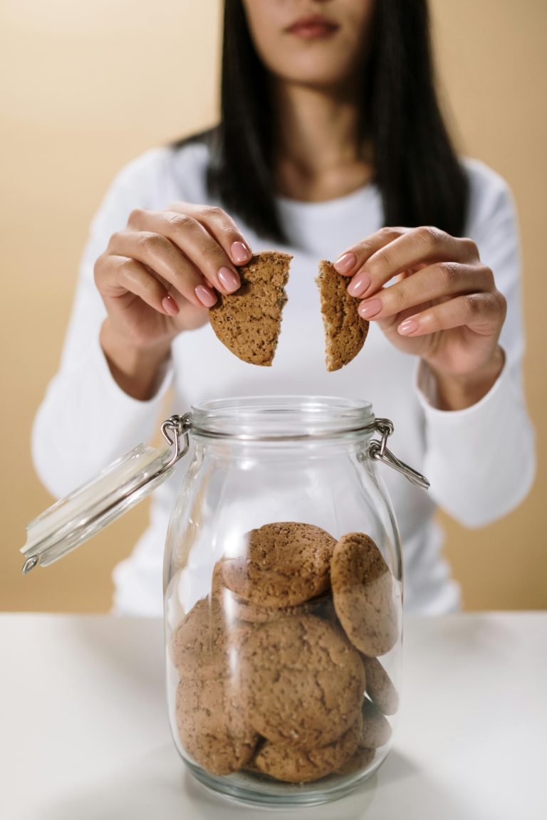 Woman breaks a cookie in half, illustrating the changes in cookie and privacy rules.