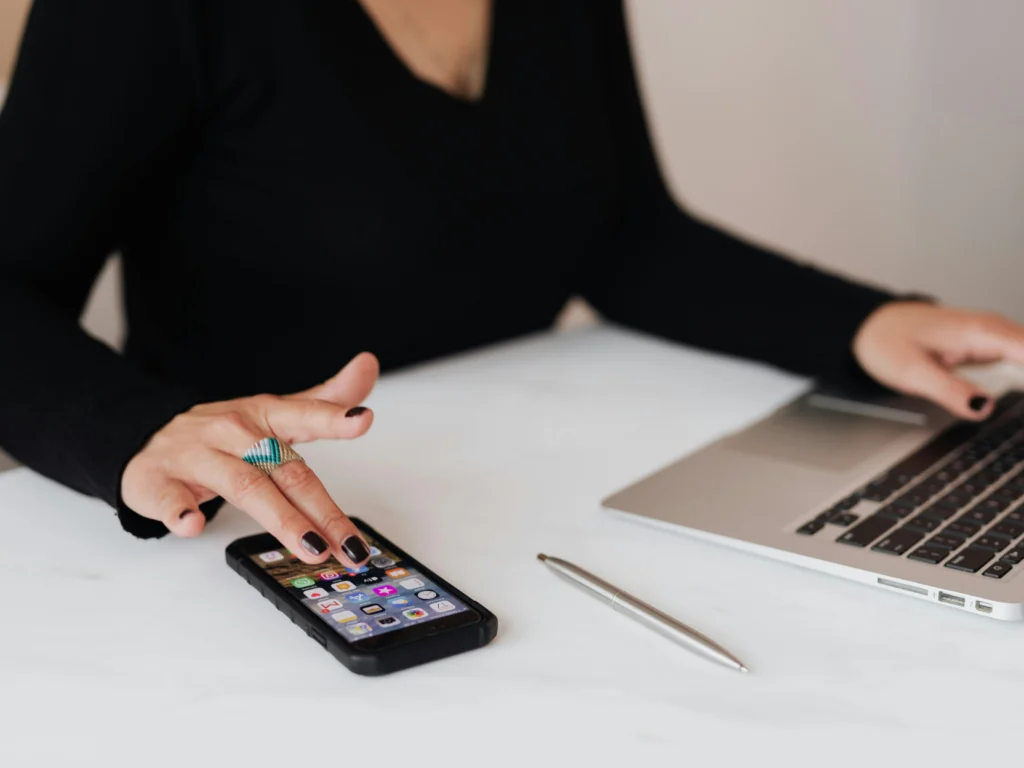 picture-of-a-female-using-a-mobile-and-laptop-while-sat-at-desk-article