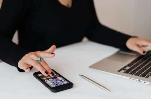 picture-of-a-female-using-a-mobile-and-laptop-while-sat-at-desk-article